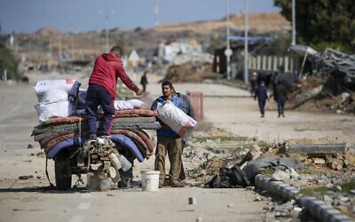 نازحون فلسطينيون يحملون أمتعتهم على عربة بالقرب من حاجز على طريق صلاح الدين في النصيرات في 25 يناير 2025، أثناء انتظارهم العودة إلى منازلهم في الجزء الشمالي من قطاع غزة. قالت إسرائيل في 25 يناير إنها ستمنع عودة النازحين الفلسطينيين إلى منازلهم في شمال غزة حتى يتم إطلاق سراح الرهينة المدنية أربيل يهود. (Photo by Eyad BABA / AFP)