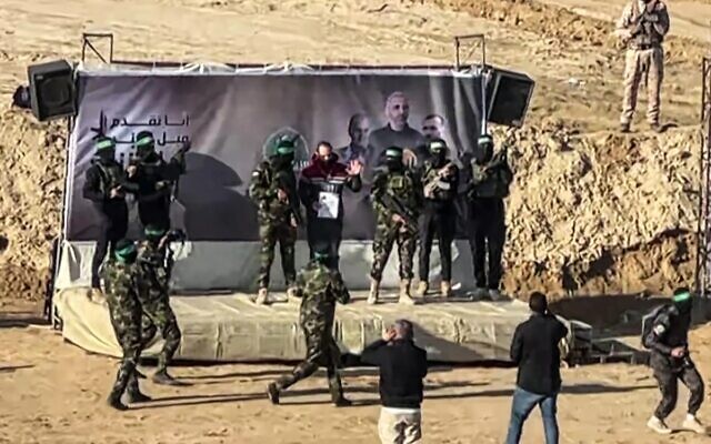الرهينة الإسرائيلي ياردن بيباس يلوح على منصة أقامتها حماس قبل تسليمه إلى الصليب الأحمر عند إطلاق سراحه، في خان يونس في جنوب قطاع غزة، 1 فبراير 2025. (AFPTV / AFP)