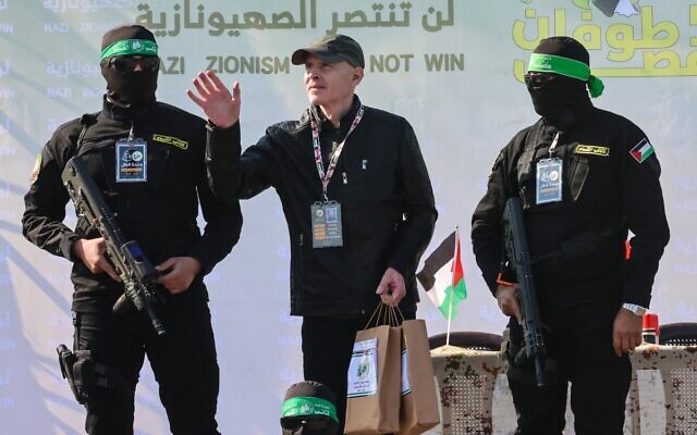 مسلحون من حركة حماس يحيطون بالرهينة الأمريكي الإسرائيلي كيث سيغل على خشبة منصة قبل تسليمه إلى فريق الصليب الأحمر في مدينة غزة في 1 فبراير 2025، كجزء من عملية تسليم الرهائن الرابعة. (Omar AL-QATTAA / AFP)