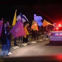 إسرائيليون يصطفون على جانب طريق سريع في جنوب إسرائيل أثناء نقل الشرطة رفات رهائن قتلى إلى المركز الوطني للطب الشرعي في تل أبيب، 27 فبراير 2025. (Israel Police)