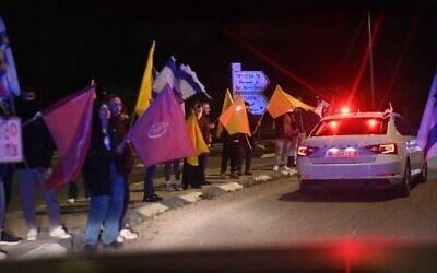 إسرائيليون يصطفون على جانب طريق سريع في جنوب إسرائيل أثناء نقل الشرطة رفات رهائن قتلى إلى المركز الوطني للطب الشرعي في تل أبيب، 27 فبراير 2025. (Israel Police)