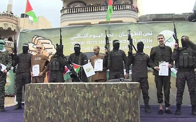 الرهائن أيلي شرعبي وأور ليفي وأوهاد بن عامي يقفون على المنصة التي أعدتها حركة حماس قبل تسليمهم للصليب الأحمر في دير البلح بقطاع غزة، 8 فبراير، 2025. (YouTube Screenshot)