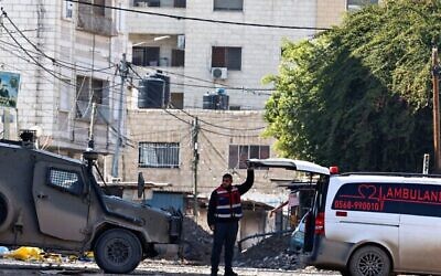 مسعف فلسطيني يفتح الجزء الخلفي من سيارة إسعاف، بناء على أمر من القوات الإسرائيلية عند حاجز، أثناء عملية عسكرية في جنين بالضفة الغربية، في 29 يناير، 2025. (زين جعفر / وكالة الصحافة الفرنسية)