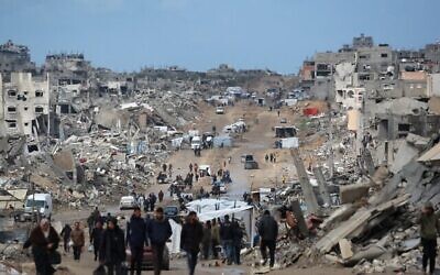 فلسطينيون نازحون يسيرون عبر طريق موحل وسط الدمار في جباليا في شمال قطاع غزة في 6 فبراير، 2025.  (Bashar TALEB / AFP)