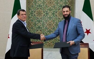 صورة نشرتها وكالة الأنباء السورية الرسمية (سانا) تظهر الرئيس السوري الانتقالي أحمد الشرع (يمين) يصافح قائد قوات سوريا الديمقراطية مظلوم عبدي بعد توقيع اتفاقا يقضي بدمج مؤسسات الإدارة الذاتية الكردية في إطار الدولة السورية، في العاصمة السورية دمشق في 10 مارس 2025. (SANA / AFP)