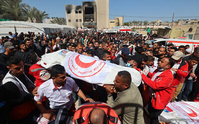 مسعفون من الهلال الأحمر الفلسطيني وخدمات الطوارئ الأخرى يحملون جثامين زملائهم الذين قُتلوا قبل أسبوع في غارة إسرائيلية، خلال موكب تشييع جثامينهم في مستشفى ناصر في خان يونس جنوب قطاع غزة في 31 مارس 2025. (Eyad BABA / AFP)