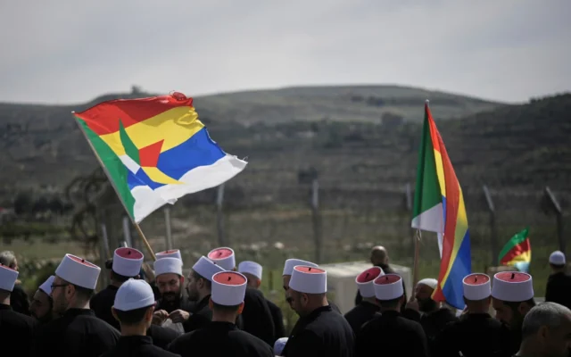 رجال دين دروز ينتظرون وصول حافلات تقل وفدًا من الطائفة الدرزية للعبور من سوريا، بالقرب من الحدود في قرية مجدل شمس بمرتفعات الجولان، شمال إسرائيل، 14 مارس 2025. (AP Photo/Leo Correa) رجال دين دروز ينتظرون وصول حافلات تقل وفدًا من الطائفة الدرزية للعبور من سوريا، بالقرب من الحدود في قرية مجدل شمس بمرتفعات الجولان، شمال إسرائيل، 14 مارس 2025. (AP Photo/Leo Correa)