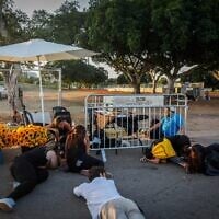 أشخاص يحتمون بعد انطلاق صفارات الإنذار للتحذير من صاروخ قادم من اليمن، في متنزه ياركون بتل أبيب، 7 أكتوبر 2024. (Miriam Alster/Flash90)