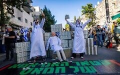متظاهرون يسخرون من رئيس الوزراء بنيامين نتنياهو، الذي تم استجوابه في ذلك اليوم في التحقيق في علاقات مساعديه مع قطر، ويشيرون إلى سياسته في تسهيل المدفوعات القطرية إلى غزة التي تديرها حماس لسنوات؛ القدس، 31 مارس 2025. (Yonatan Sindel/Flash90)