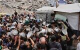 فلسطينيون يكافحون للحصول على طعام متبرع به في مطبخ مجتمعي في جباليا، شمال قطاع غزة، الخميس 15 مايو 2025. (AP Photo/Jehad Alshrafi)
