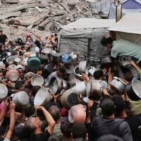 فلسطينيون يكافحون للحصول على طعام متبرع به في مطبخ مجتمعي في جباليا، شمال قطاع غزة، الخميس 15 مايو 2025. (AP Photo/Jehad Alshrafi)