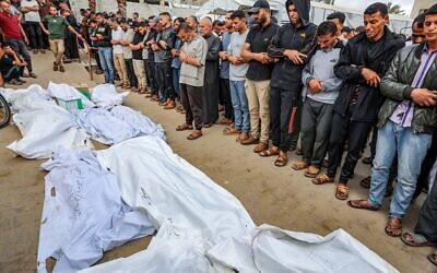 فلسطينيون يشيعون جثامين أشخاص قُتلوا في غارة جوية إسرائيلية خارج مستشفى ناصر في خان يونس، جنوب قطاع غزة، 18 مايو 2025. (Abed Rahim Khatib/Flash90)