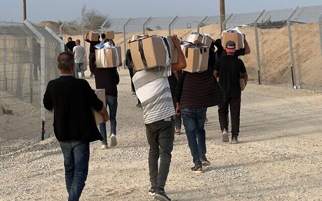فلسطينيون يتسلمون صناديق مساعدات إنسانية في موقع توزيع تديره مؤسسة غزة الإنسانية، 26 مايو، 2025. (GHF) فلسطينيون يتسلمون صناديق مساعدات إنسانية في موقع توزيع تديره مؤسسة غزة الإنسانية، 26 مايو، 2025. (GHF)