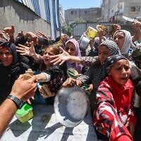 فلسطينيون يصطفون للحصول على وجبة ساخنة في مطبخ خيري يديره برنامج الأغذية العالمي التابع للأمم المتحدة في مخيم النصيرات في وسط قطاع غزة، 26 أبريل 2025. (Eyad BABA / AFP)