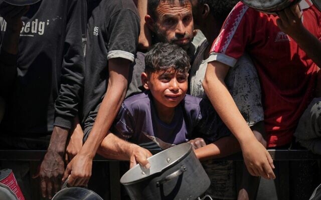 فلسطينيون يتدافعون للحصول على الطعام المطبوخ الموزع في مطبخ مجتمعي في منطقة المواصي بخان يونس، في قطاع غزة، 23 مايو 2025. (AP Photo/Abdel Kareem Hana) فلسطينيون يتدافعون للحصول على الطعام المطبوخ الموزع في مطبخ مجتمعي في منطقة المواصي بخان يونس، في قطاع غزة، 23 مايو 2025. (AP Photo/Abdel Kareem Hana)