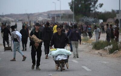 فلسطينيون يحملون مساعدات إنسانية من نقطة توزيع في مخيم البريج للاجئين وسط قطاع غزة، 9 يونيو 2025. (Eyad BABA / AFP)