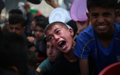 أطفال فلسطينيون ينتظر,k الحصول على الطعام في نقطة توزيع في مخيم النصيرات وسط قطاع غزة، 11 يونيو 2025. (Eyad BABA / AFP)