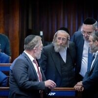 أعضاء الكنيست من حزب "يهدوت هتوراة" يتشاورون في جلسة للهيئة العامة للكنيست، 4 ديسمبر 2024. (Chaim Goldbergl/Flash90)