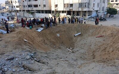 فلسطينيون يتجمعون حول حفرة ضخمة بعد أن ضربت غارة إسرائيلية خيام النازحين في حي الرمال شمال مدينة غزة في 28 يونيو 2025. (Omar AL-QATTAA / AFP)