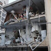 رجال الإنقاذ يعملون في مبنى متضرر بعد هجوم بصاروخ إيراني في مدينة بات يام، جنوب تل أبيب، في وقت مبكر من يوم 15 يونيو 2025. (Jack Guez / AFP)