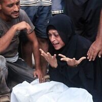 امرأة فلسطينية تنعى جثة رجل قيل إنه قُتل بالقرب من مركز توزيع الأغذية الذي تديره مؤسسة غزة الإنسانية، وهي منظمة مدعومة من الولايات المتحدة وإسرائيل، في مستشفى ناصر في 19 يوليو 2025 (أ ف ب)