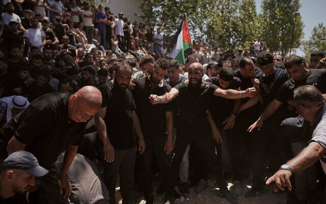 مشيعون يحتشدون  حول قبري الفلسطيني الأمريكي سيف الله مصلط (20 عامًا) ومحمد الشلبي خلال جنازتهما في قرية المزرعة الشرقية بالضفة الغربية، يوم الأحد، 13 يوليو 2025. (AP/Leo Correa)