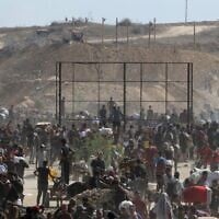 فلسطينيون نازحون يتجمعون لتلقي المساعدات من مركز توزيع المساعدات التابع لمؤسسة غزة الإنسانية في منطقة محور نتساريم في وسط قطاع غزة، 30 يوليو 2025. (Eyad Baba/AFP)