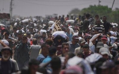 فلسطينيون يحملون أكياسا تحتوي على مواد غذائية ومساعدات إنسانية قدمتها مؤسسة غزة الإنسانية في رفح، جنوب قطاع غزة، 9 يونيو 2025. (AP Photo/Abdel Kareem Hana)