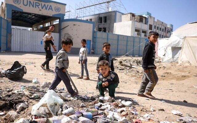 أطفال يلعبون حول النفايات أمام مقر وكالة الأمم المتحدة لإغاثة وتشغيل اللاجئين الفلسطينيين (الأونروا) المغلق في مدينة غزة، 20 مايو 2025. (Bashar TALEB / AFP)