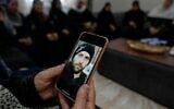 حليمة عياد، والدة الفلسطيني الأمريكي المقتول خميس عياد، تحمل هاتفًا محمولًا عليه صورة ابنها في منزل العائلة في سلواد، شرقي رام الله، 31 يوليو/تموز 2025. (أسوشيتد برس/ناصر ناصر)