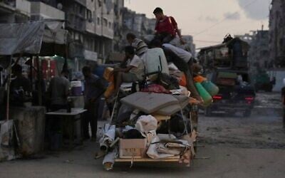فلسطينيون نازحون فارون من جباليا يتنقلون مع أمتعتهم في أحد شوارع مدينة غزة، 26 أغسطس/آب 2025. (أسوشيتد برس/جهاد الشرفي)