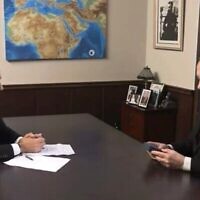 رئيس الوزراء بنيامين نتنياهو ينظر إلى تميمة عليها "خريطة الأرض الموعودة"، أعطاها له محاوره، 12 أغسطس/آب 2025. (لقطة شاشة من i24 News)