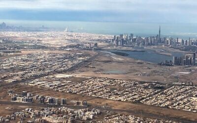 صورة جوية التقطت في 1 يناير 2022 من طائرة ركاب تظهر منظراً عاماً لإمارة دبي الخليجية مع العاصمة الإماراتية أبو ظبي في الخلفية.  (Marina Passos / AFP)