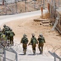 جنود إسرائيليون يقومون بدورية على طول السياج الحدودي مع سوريا بالقرب من قرية مجدل شمس الدرزية في مرتفعات الجولان في 23 يوليو 2025 (Jalaa MAREY / AFP)