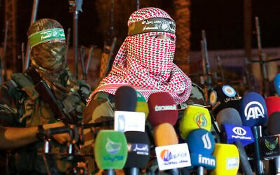 أبو عبيدة (يمين)، المتحدث باسم الجناح العسكري لحركة حماس، كتائب عز الدين القسام، يلقي بيانا في مدينة غزة في وقت متأخر من يوم 8 يوليو/تموز 2015. (محمد عبد/وكالة الصحافة الفرنسية)