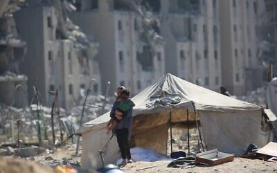 فلسطينيون نازحون بالقرب من خيامهم في مخيم النصيرات في وسط قطاع غزة، 13 سبتمبر/أيلول 2025. (علي حسن/فلاش 90)