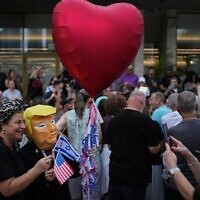 شخص يرتدي قناعًا يصور الرئيس الأمريكي دونالد ترامب، ويحتفل الإسرائيليون بعد الإعلان عن موافقة إسرائيل وحماس على المرحلة الأولى من خطة السلام لوقف القتال، تل أبيب، إسرائيل، 9 أكتوبر/تشرين الأول 2025. (AP/Emilio Morenatti)