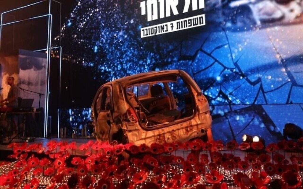 المسرح في مراسم إحياء ذكرى السابع من أكتوبر/تشرين الأول الوطنية في إسرائيل في حديقة اليركون في تل أبيب، مع سيارة محترقة دمرها مهاجمو حماس على طول حدود غزة، 7 أكتوبر/تشرين الأول 2025. (Alon Levin/Pro-Democracy Protest Movement)