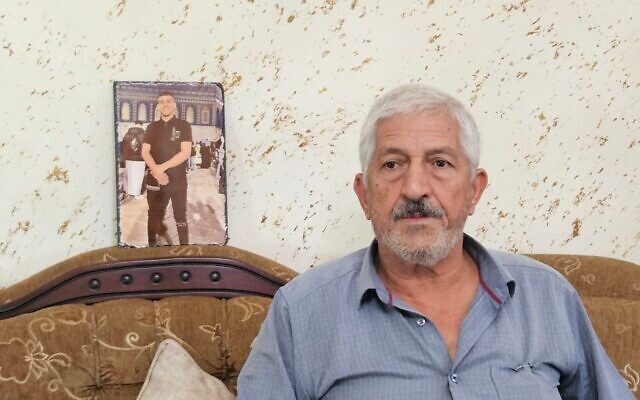 الصورة الرئيسية: محمد الرازم، والد صهيب الرازم، الذي قُتل في 7 أكتوبر/تشرين الأول 2023، بجوار صورة لابنه في منزله في بيت حنينا، القدس الشرقية، 1 أكتوبر/تشرين الأول 2025.  (Nurit Yohanan/ The Times of Israel)