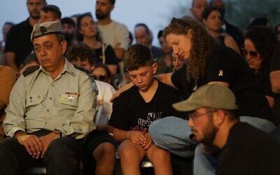 إيلا حايمي (إلى اليمين) وابنها الأكبر في جنازة زوجها، طال حايمي، الذي أعيد جثمانه من غزة قبل أيام، في كبيوتس نير يتسحاق، 22 أكتوبر 2025. . (Dana Reany/Hostages Forum)