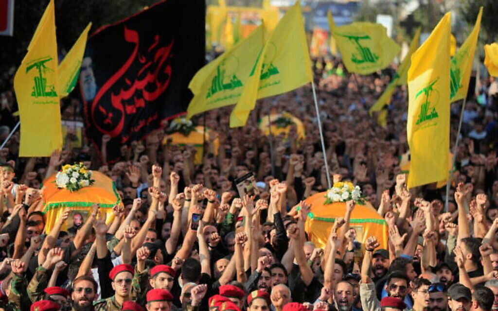يرفع مقاتلو حزب الله وأنصاره قبضاتهم ويرددون الشعارات أثناء سيرهم في موكب جنازة خمسة من رفاقهم الذين قتلوا في الغارات الإسرائيلية في الأيام الأخيرة، في مدينة النبطية الجنوبية، لبنان، 2 نوفمبر/تشرين الثاني 2025. (AP Photo/Mohammad Zaatari)
