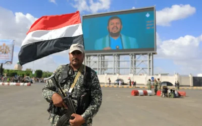 يقف أحد أفراد قوات الأمن الحوثية حارساً أمام شاشة عملاقة تبث خطاب الزعيم عبد الملك الحوثي في ​​صنعاء في 19 سبتمبر/أيلول 2025. (Mohammed HUWAIS / AFP)