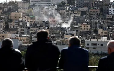 يشاهد سكان مخيم نور شمس للاجئين الفلسطينيين منازلهم وهي تُهدم عشية رأس السنة الميلادية بواسطة حفارة عسكرية إسرائيلية في مخيم نور شمس، شرق مدينة طولكرم شمال الضفة الغربية، وسط هجمات مستمرة في الضفة الغربية في 31 ديسمبر/كانون الأول 2025. (Zain JAAFAR / AFP)