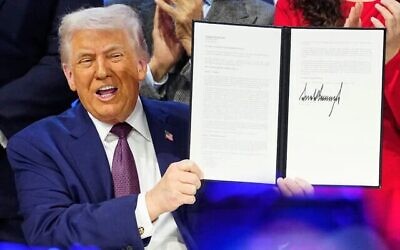 الرئيس الأمريكي دونالد ترامب يحمل الميثاق خلال حفل التوقيع على مبادرته الخاصة بمجلس السلام في الاجتماع السنوي للمنتدى الاقتصادي العالمي في دافوس بسويسرا، 22 يناير 2026. (AP Photo/Markus Schreiber)