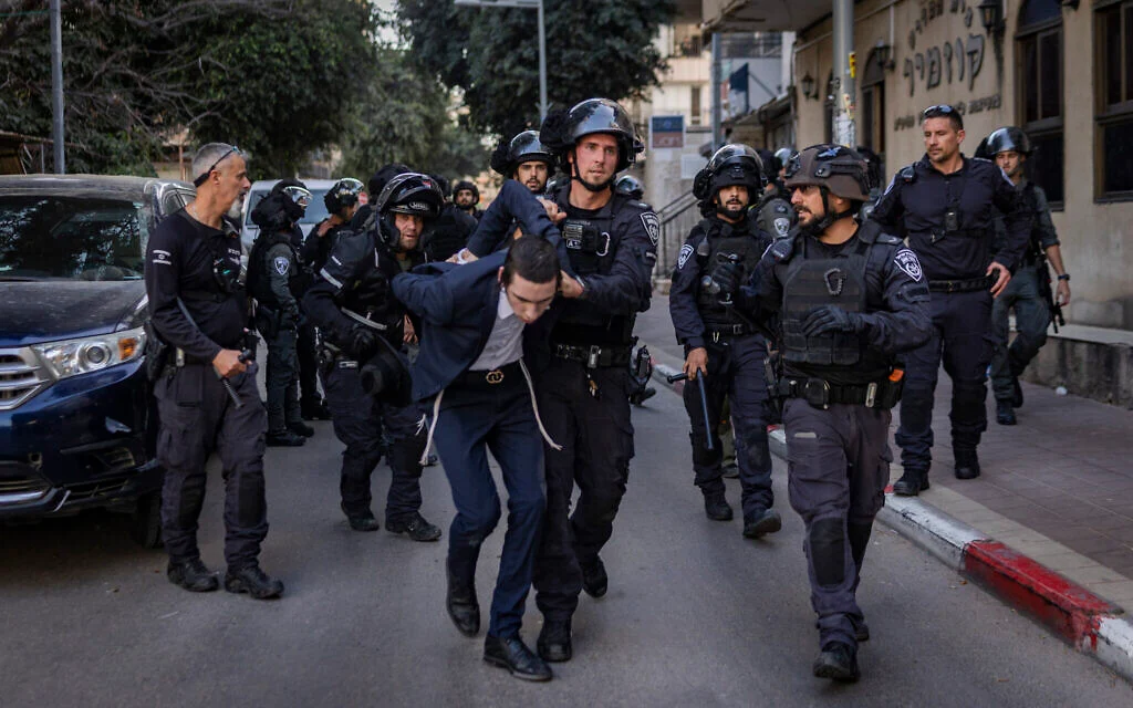 ألقت الشرطة القبض على رجل متدين متشدد خلال أعمال شغب أعقبت اعتداءً على جنديتين إسرائيليتين في بني براك، وسط إسرائيل، في 15 فبراير 2026. (Flash90) ألقت الشرطة القبض على رجل متدين متشدد خلال أعمال شغب أعقبت اعتداءً على جنديتين إسرائيليتين في بني براك، وسط إسرائيل، في 15 فبراير 2026. (Flash90)
