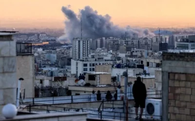 يقف شخص على سطح مبنى ينظر إلى عمود الدخان المتصاعد بعد غارة جوية على العاصمة الإيرانية طهران، في 3 مارس 2026 (Atta Kenare/AFP)