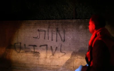 ينظر رجل فلسطيني إلى كتابة عبرية تقول "الموت للعرب" على جدار منزل متضرر في أعقاب هجوم مزعوم شنه مستوطنون إسرائيليون في قرية دير خطاب، شرق نابلس في الضفة الغربية، في 22 مارس/آذار 2026. (Zain JAAFAR / AFP)