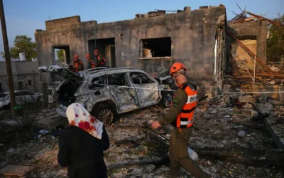 سكان وضباط من قيادة الجبهة الداخلية الإسرائيلية يتفقدون منزلاً دمره صاروخ إيراني في بلدة الزرازير الشمالية، 13 مارس 2026. (AP Photo/Ariel Schalit)