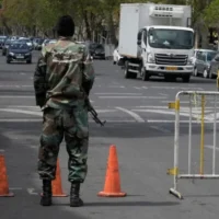 فرد من قوات البسيج شبه العسكرية يقف عند نقطة تفتيش في طهران، إيران، 29 مارس 2026. (Vahid Salemi/AP)