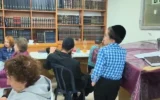 إسرائيليون يتجمعون في ملجأ للحماية من القنابل مزدوج الاستخدام في عراد، يُستخدم أيضاً ككنيس حريدي، خلال إنذار من هجوم صاروخي إيراني على جنوب إسرائيل في 25 مارس 2026. (Courtesy/Lilach Inbar Haviv)
